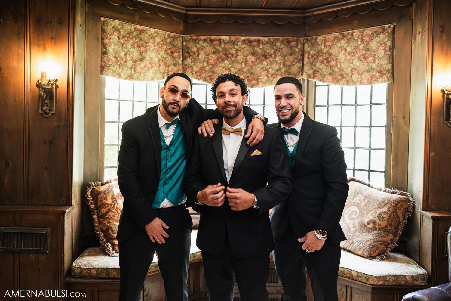Three groomsmen in formal attire posing together in an elegant wood-paneled room.