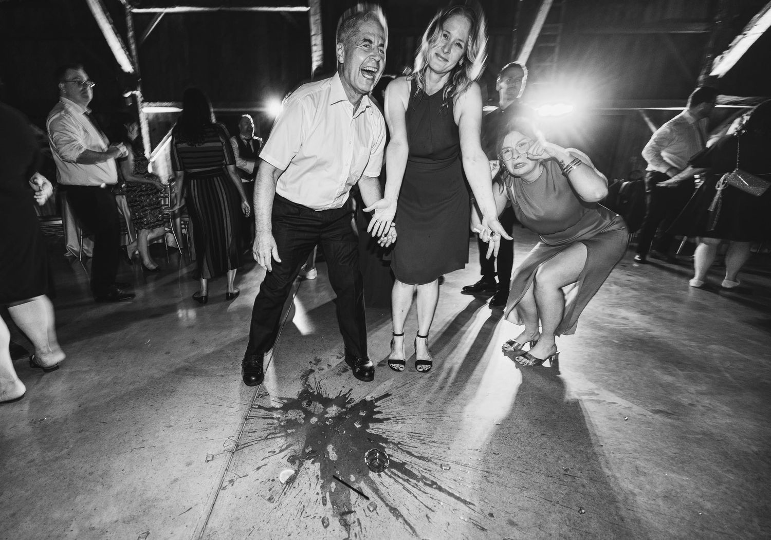 Black and white photo of guests dancing energetically at wedding reception.