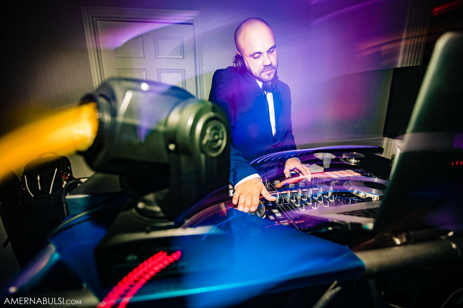 DJ performs at wedding reception with colorful purple and blue lighting effects.