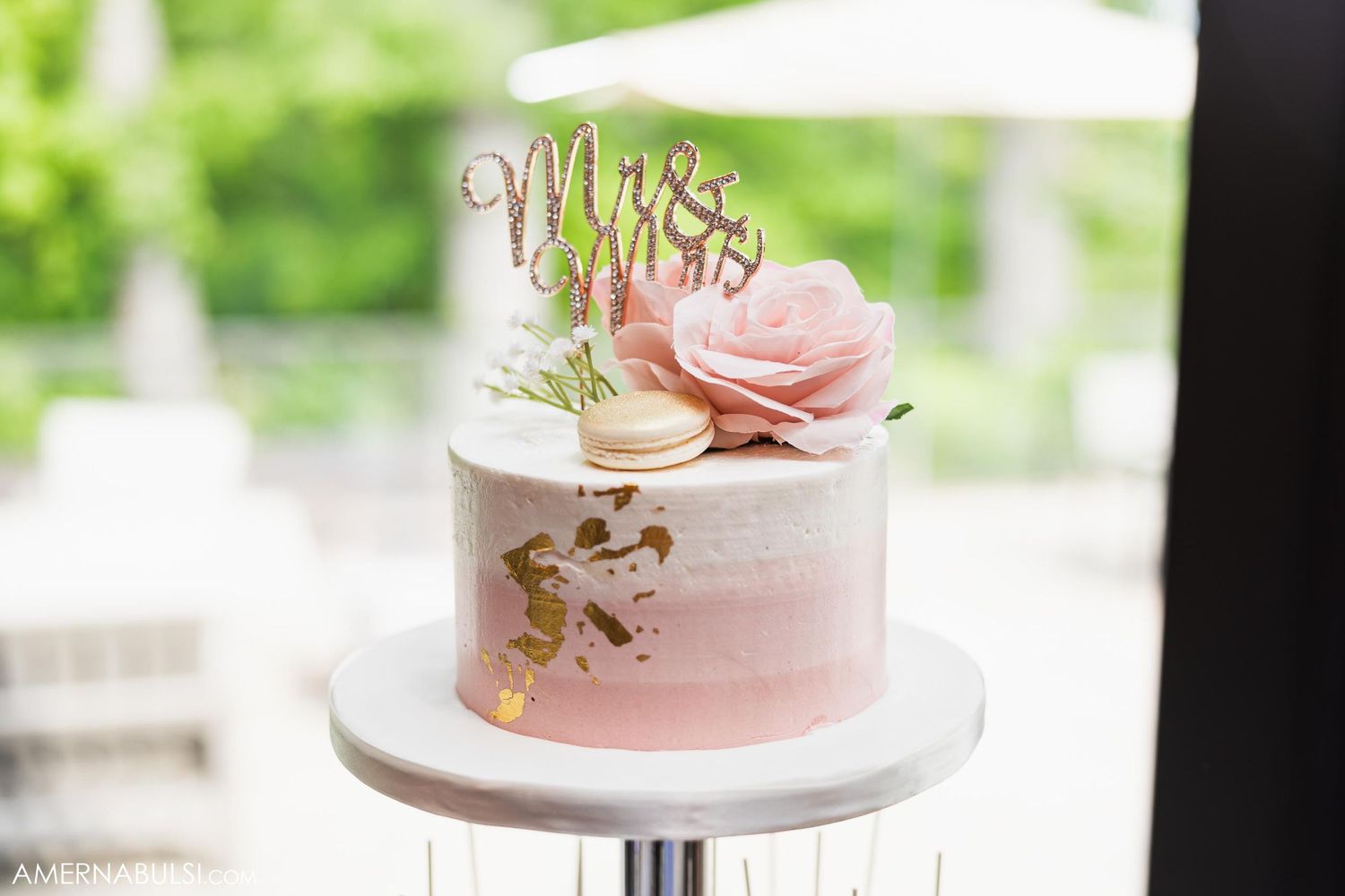 Small pink ombre wedding cake decorated with gold accents and rose sugar flower.