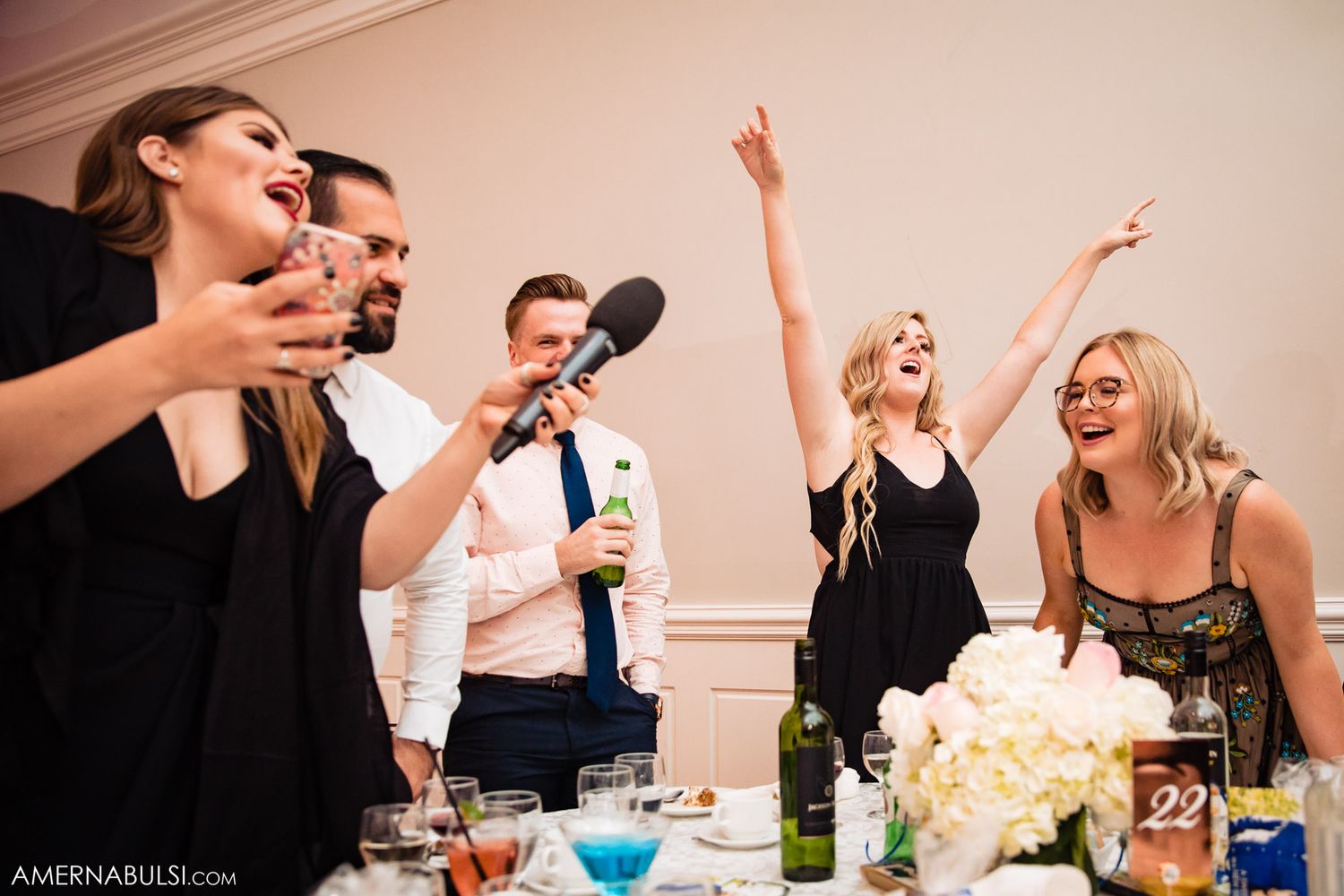 Wedding guests and party members celebrate with lively reactions during reception toasts and speeches.