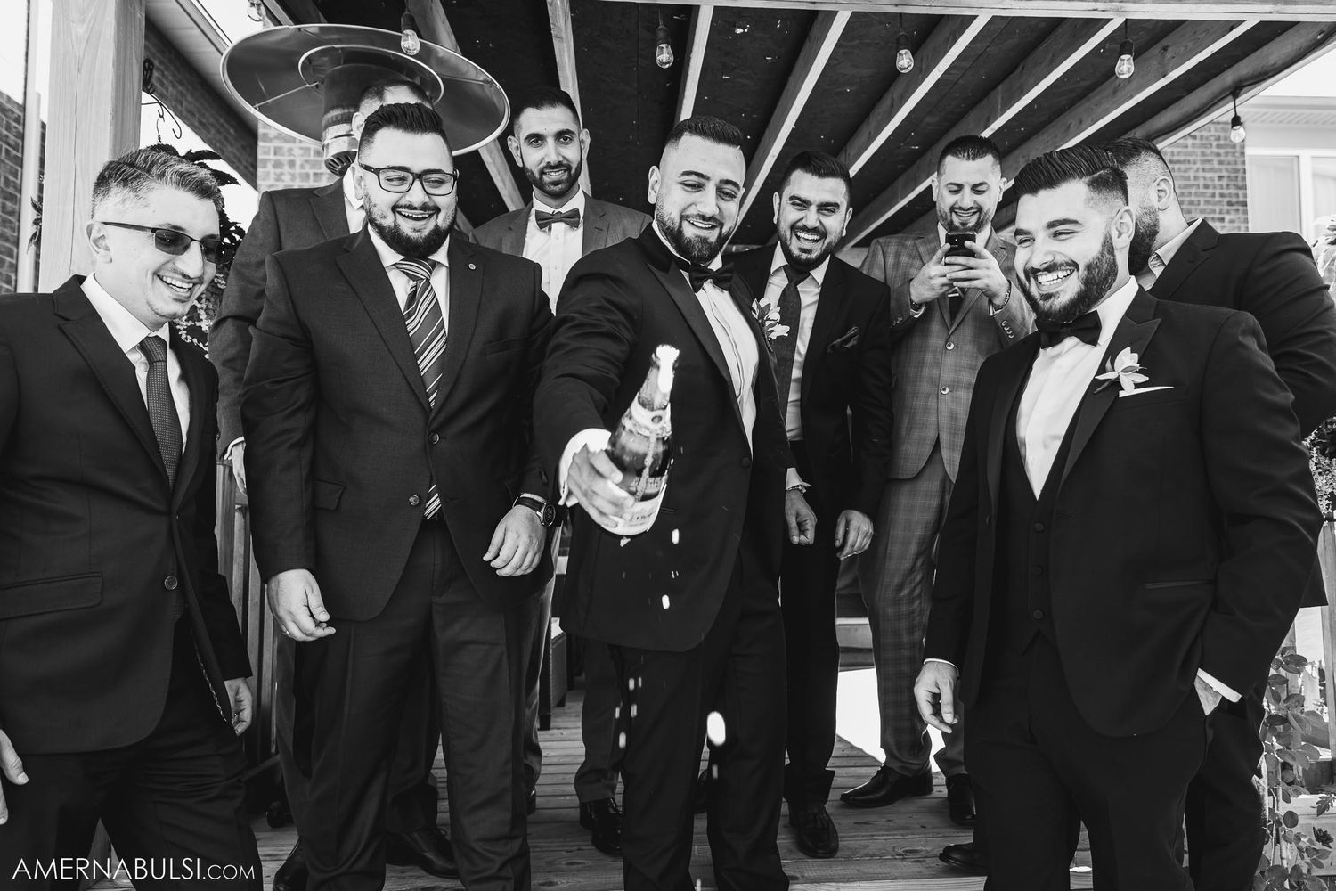 Black and white photo of groomsmen in tuxedos posing together.
