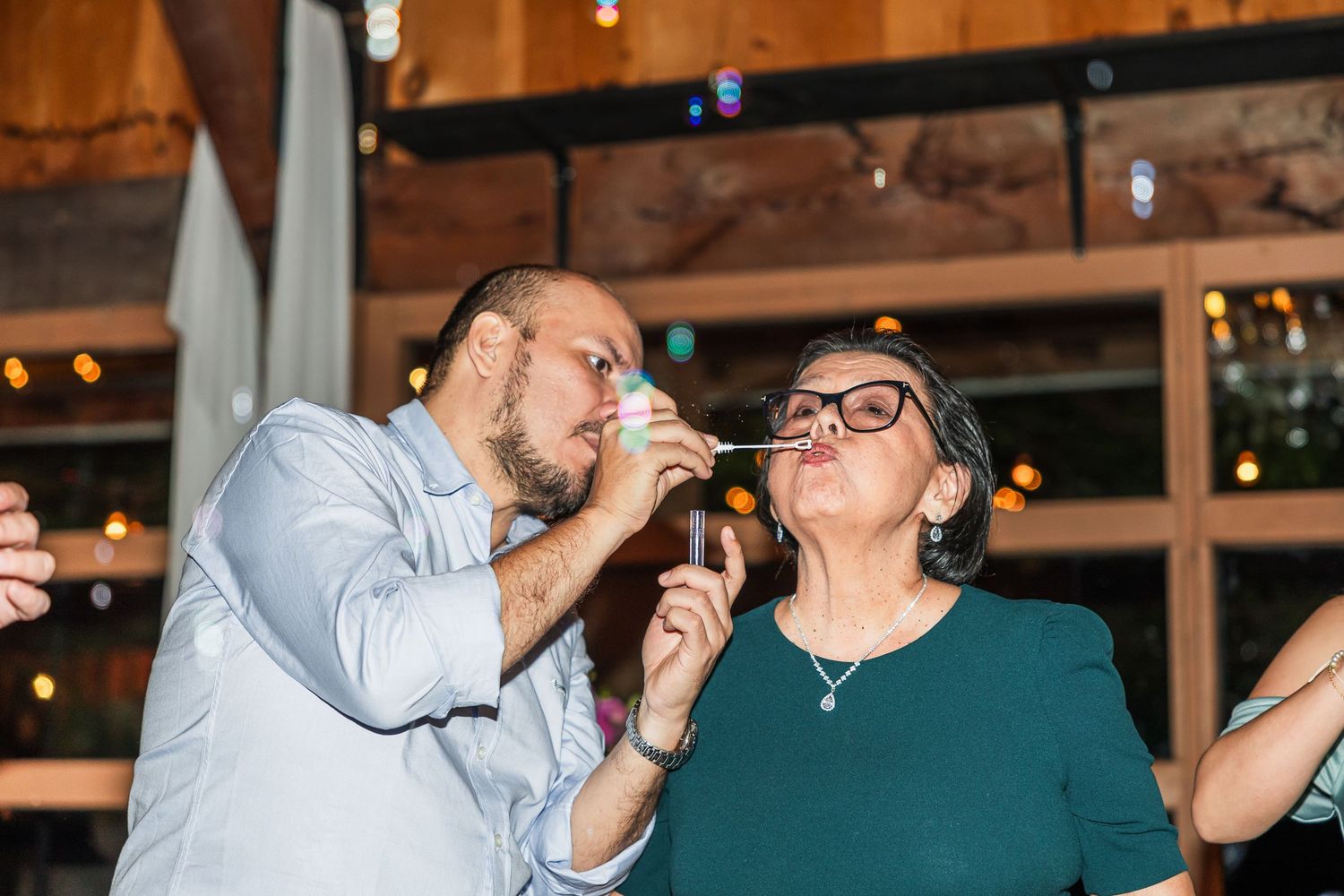 Two guests sharing a fun moment doing shots together at a festive indoor party celebration.