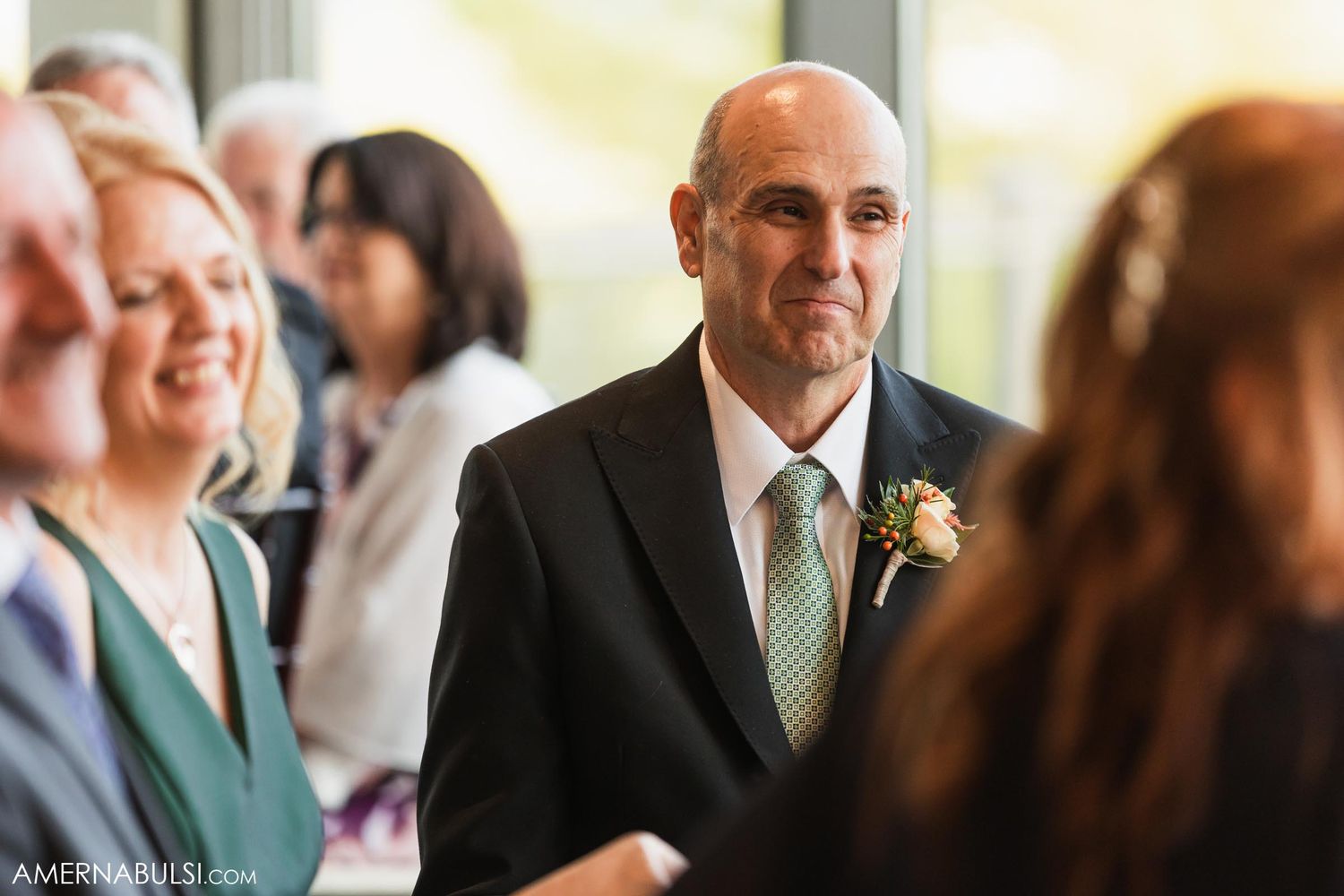 Wedding guest in formal attire mingles during reception.