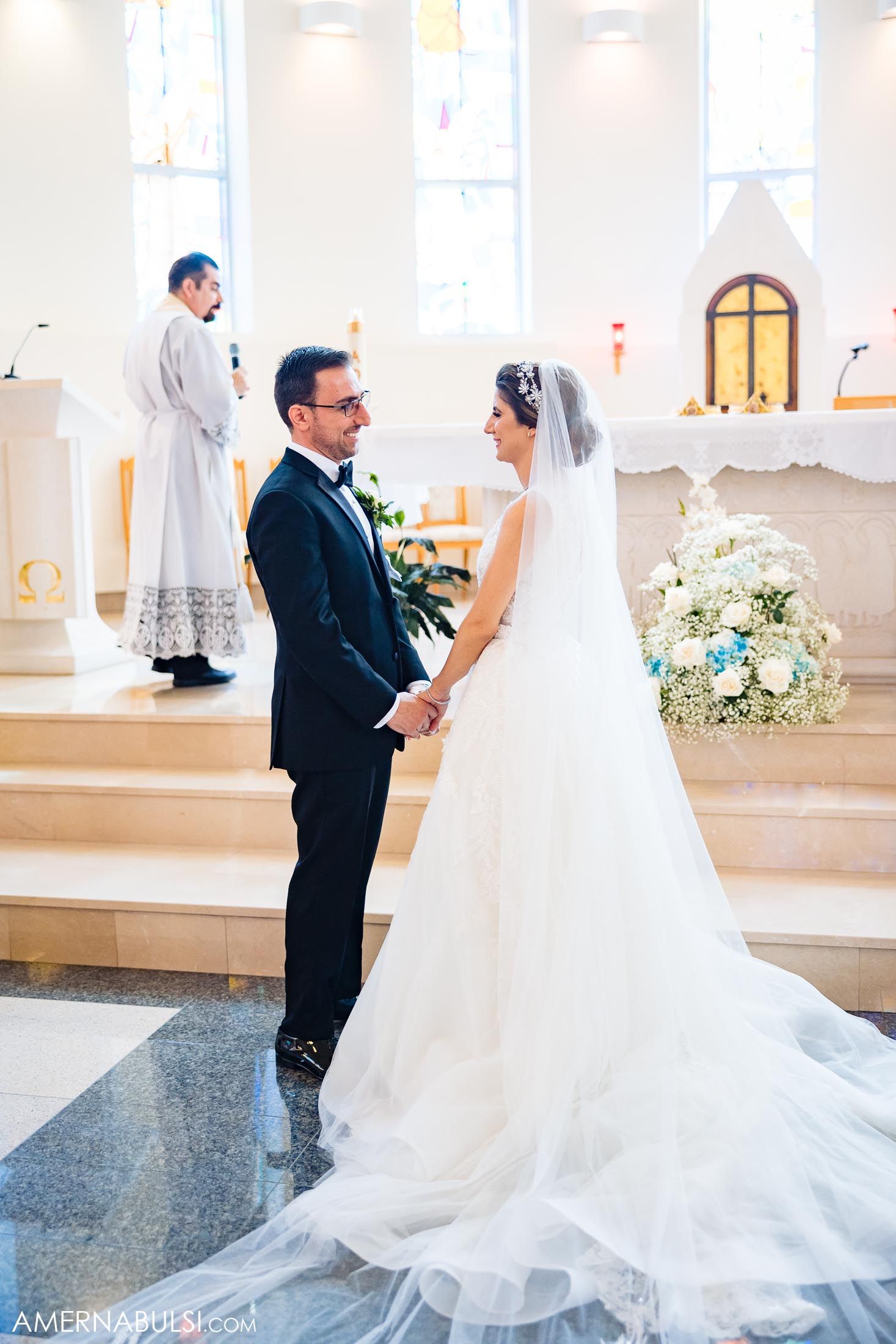 Elegant church wedding ceremony with flowing white bridal gown and traditional decorations.