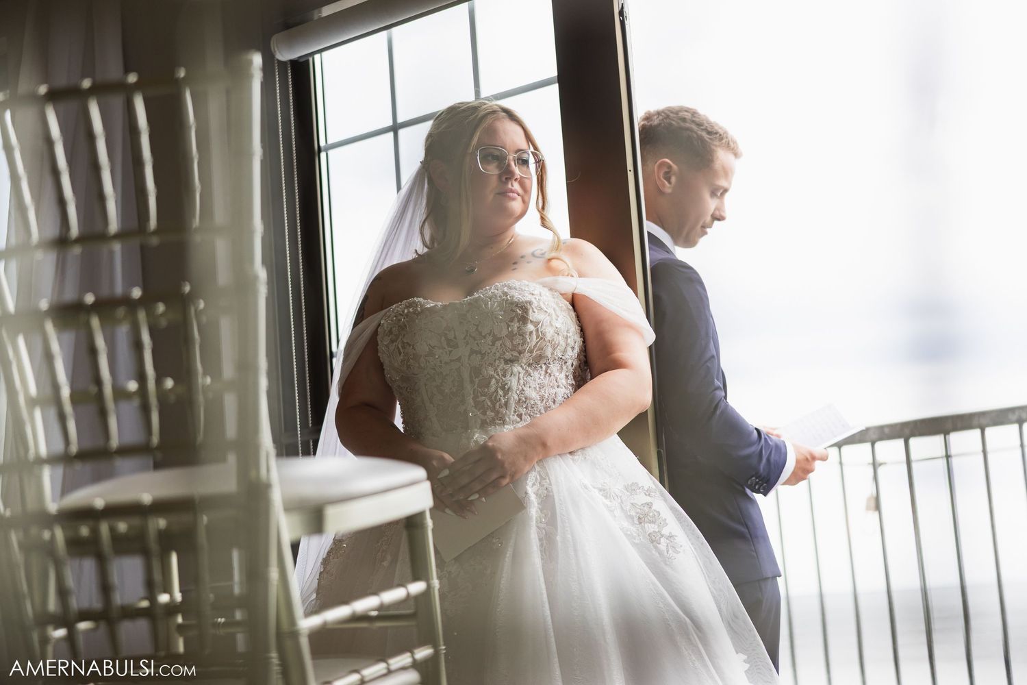Light streams through windows illuminating a couple in an elegant indoor setting.