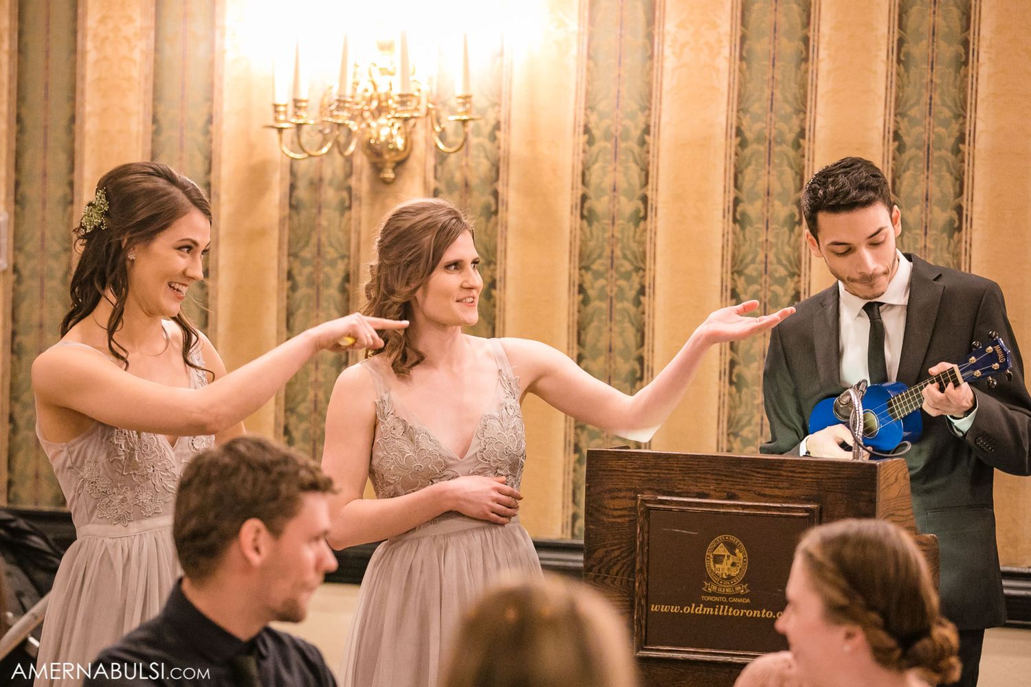 Wedding guests enjoying conversation at an elegant banquet hall with ornate wall decorations.