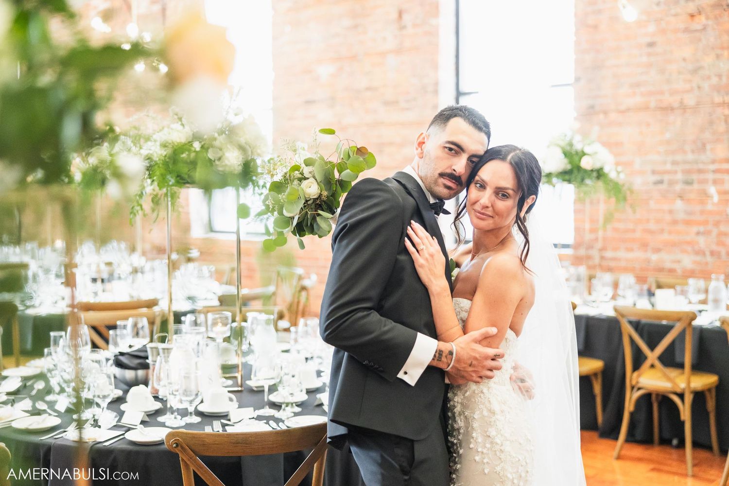 A romantic moment captured during a wedding reception with elegant table settings and floral decorations.