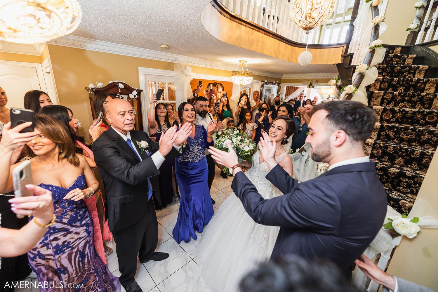 Wedding reception guests dancing and celebrating in an elegant venue with formal attire.