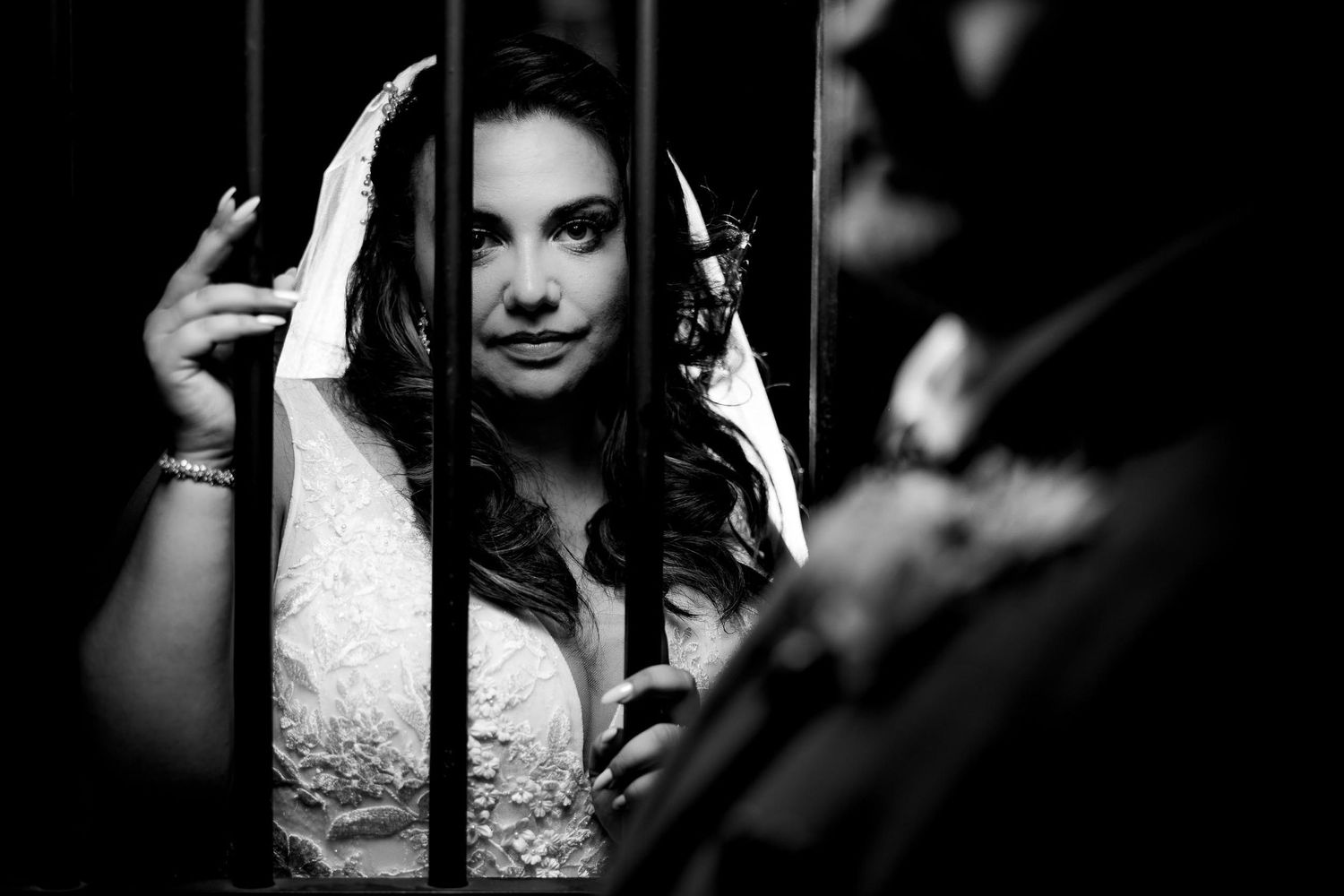 Black and white portrait shot of long dark hair with headphones against dark background.