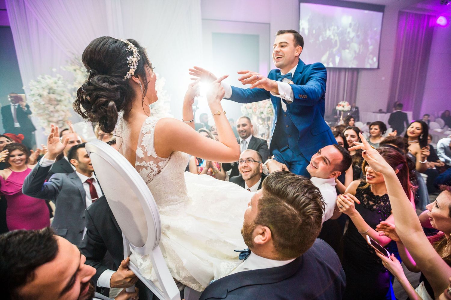 Energetic wedding reception scene with guests dancing and celebrating.