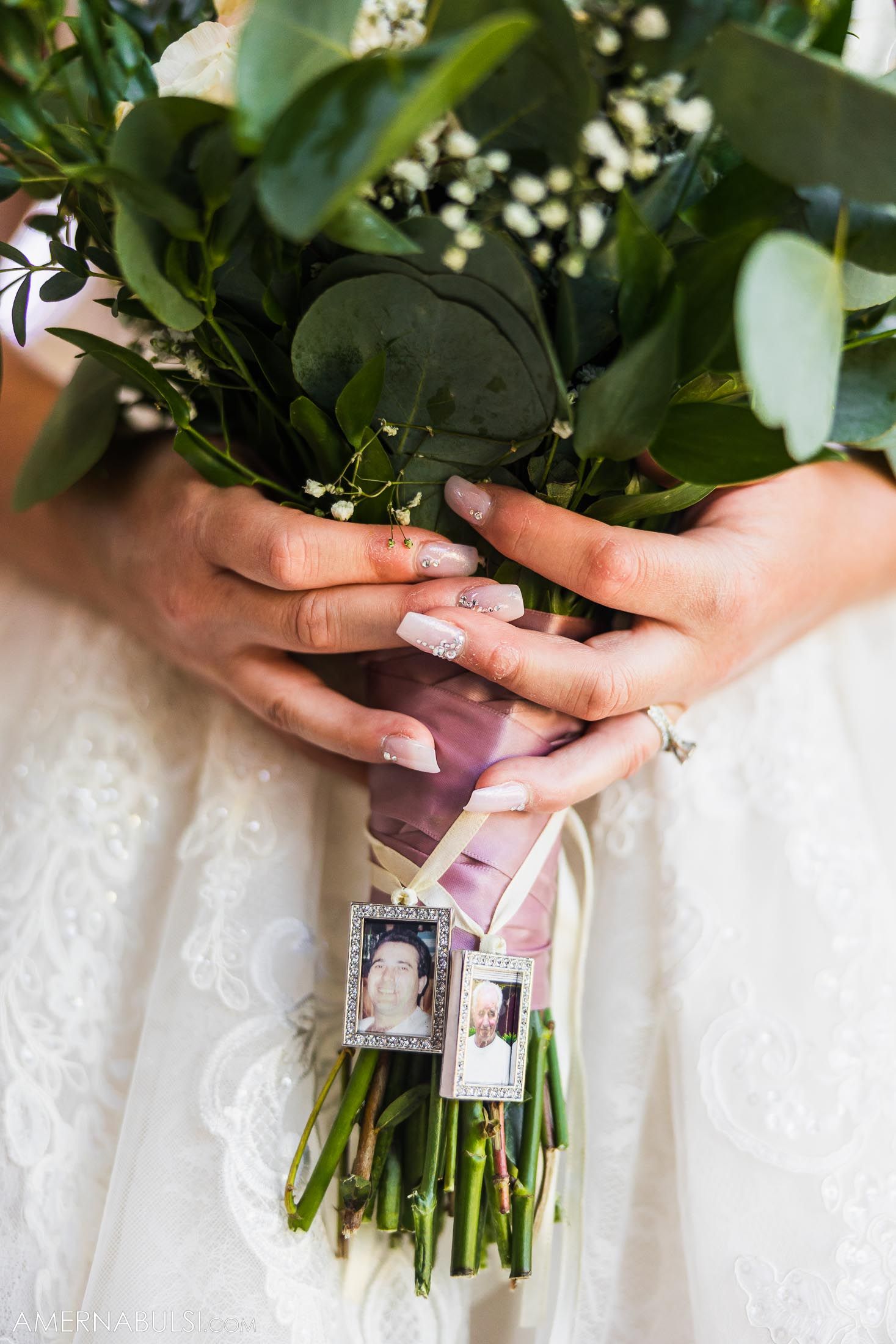 Wedding bouquet close-up showing hands holding flowers with memorial photos attached to stems.