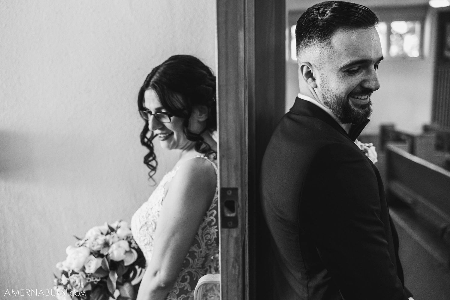 Wedding ceremony in a church with wooden pews and vaulted ceiling as couple walks down aisle.