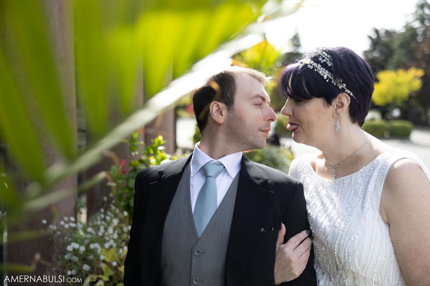 Intimate wedding portrait captured in a garden setting with soft natural lighting.