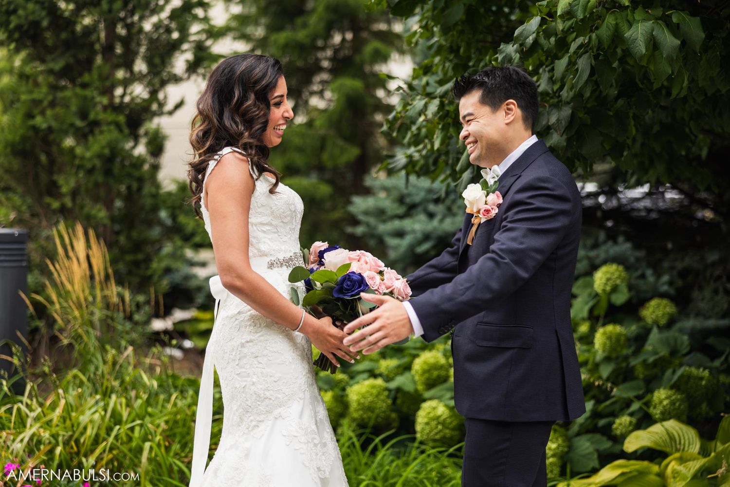 Couple exchanges items during outdoor garden ceremony.