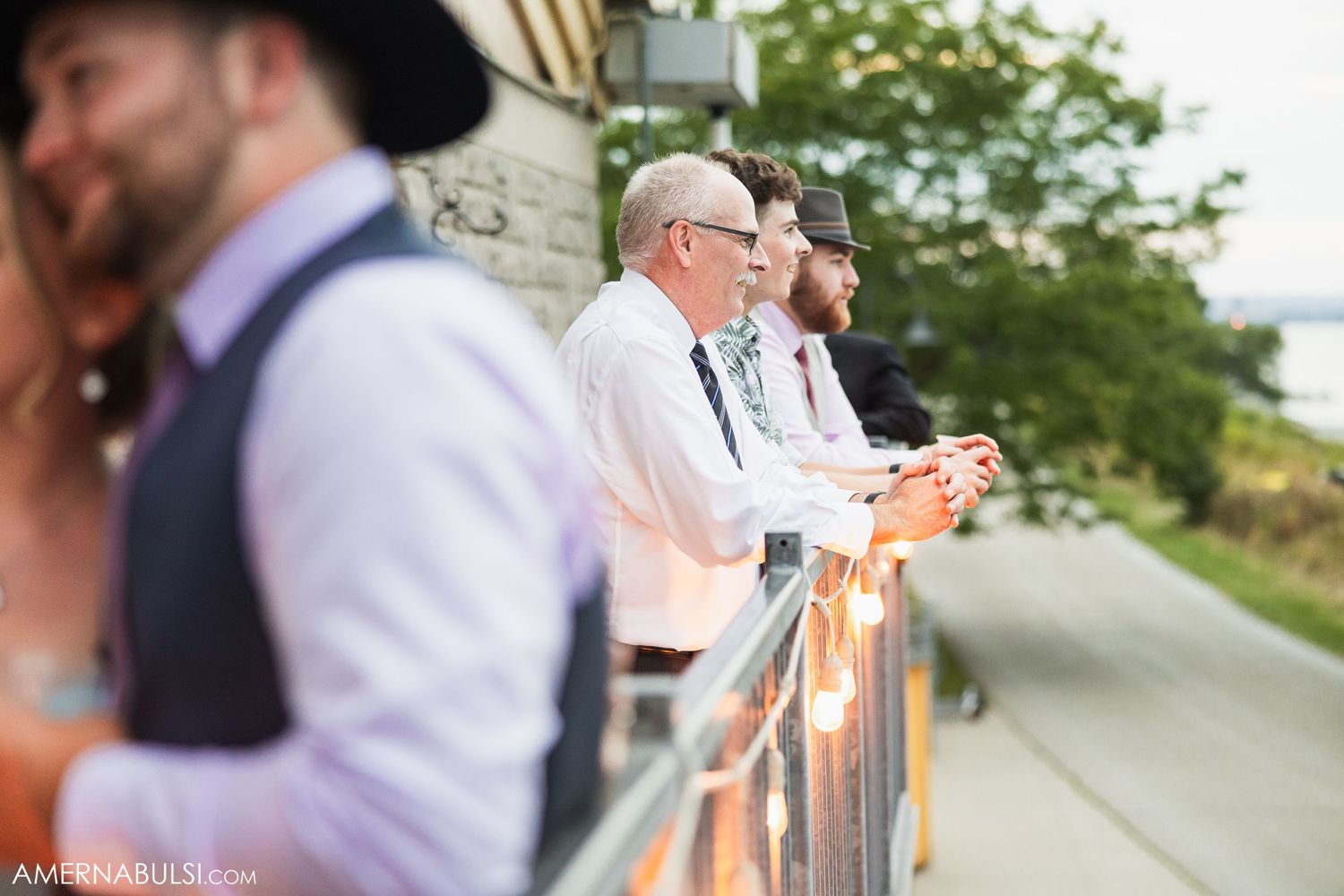 Outdoor wedding reception venue with natural greenery and white decorations.