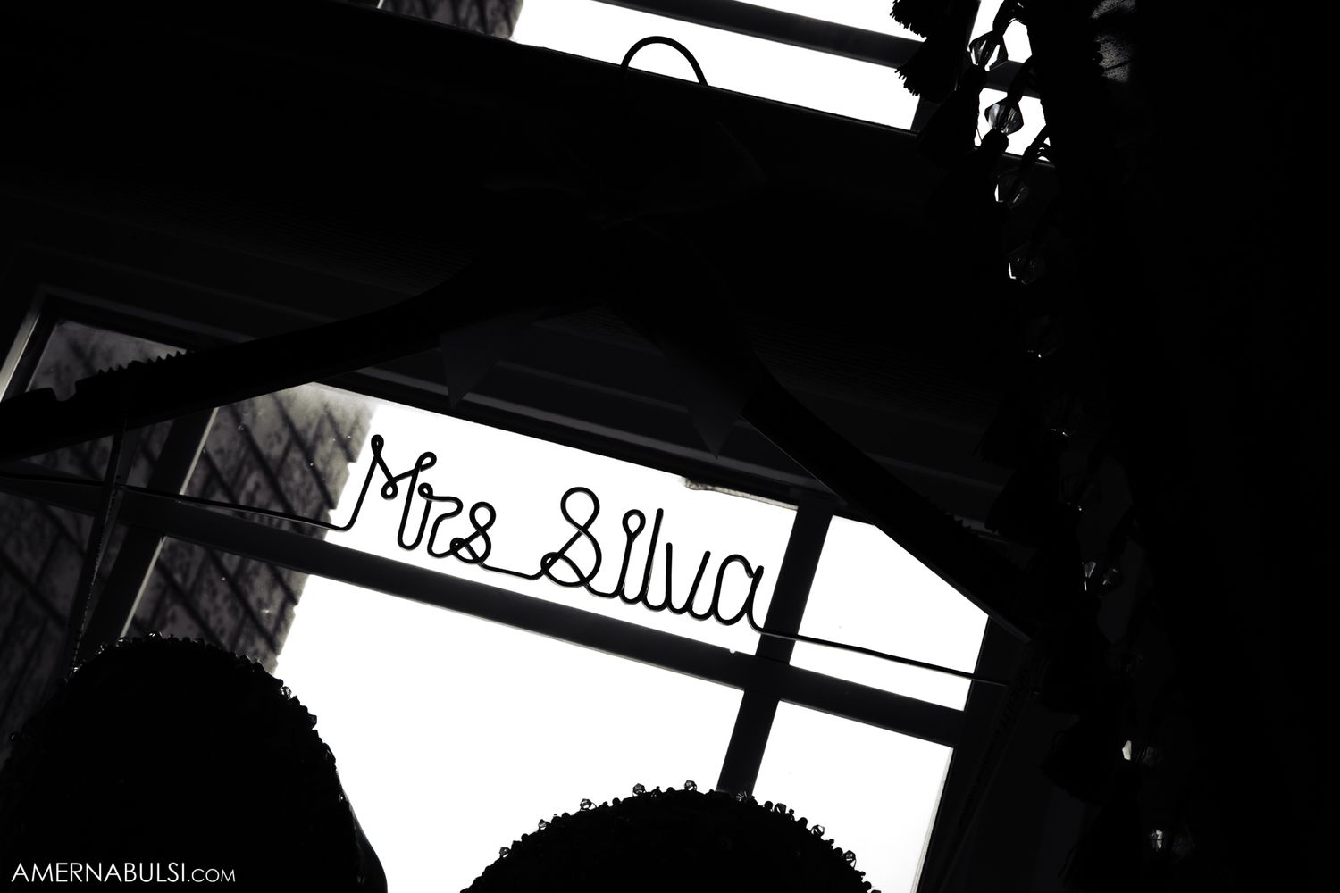 Black and white photograph showing a window with 'Mrs. Silva' handwritten text visible on the glass.