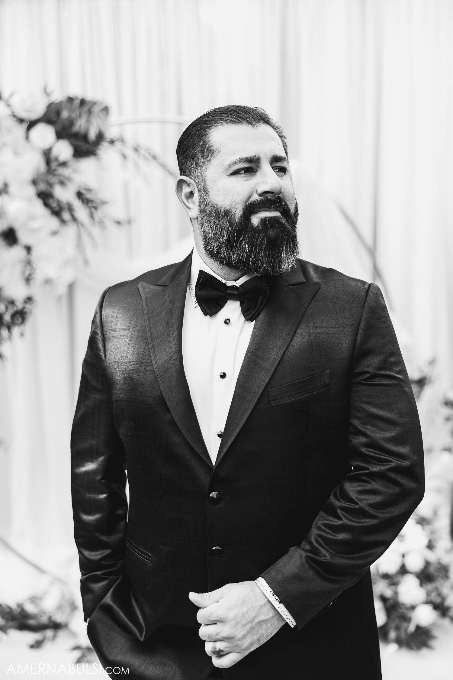 Classic black and white portrait of a groom in tuxedo and bowtie.