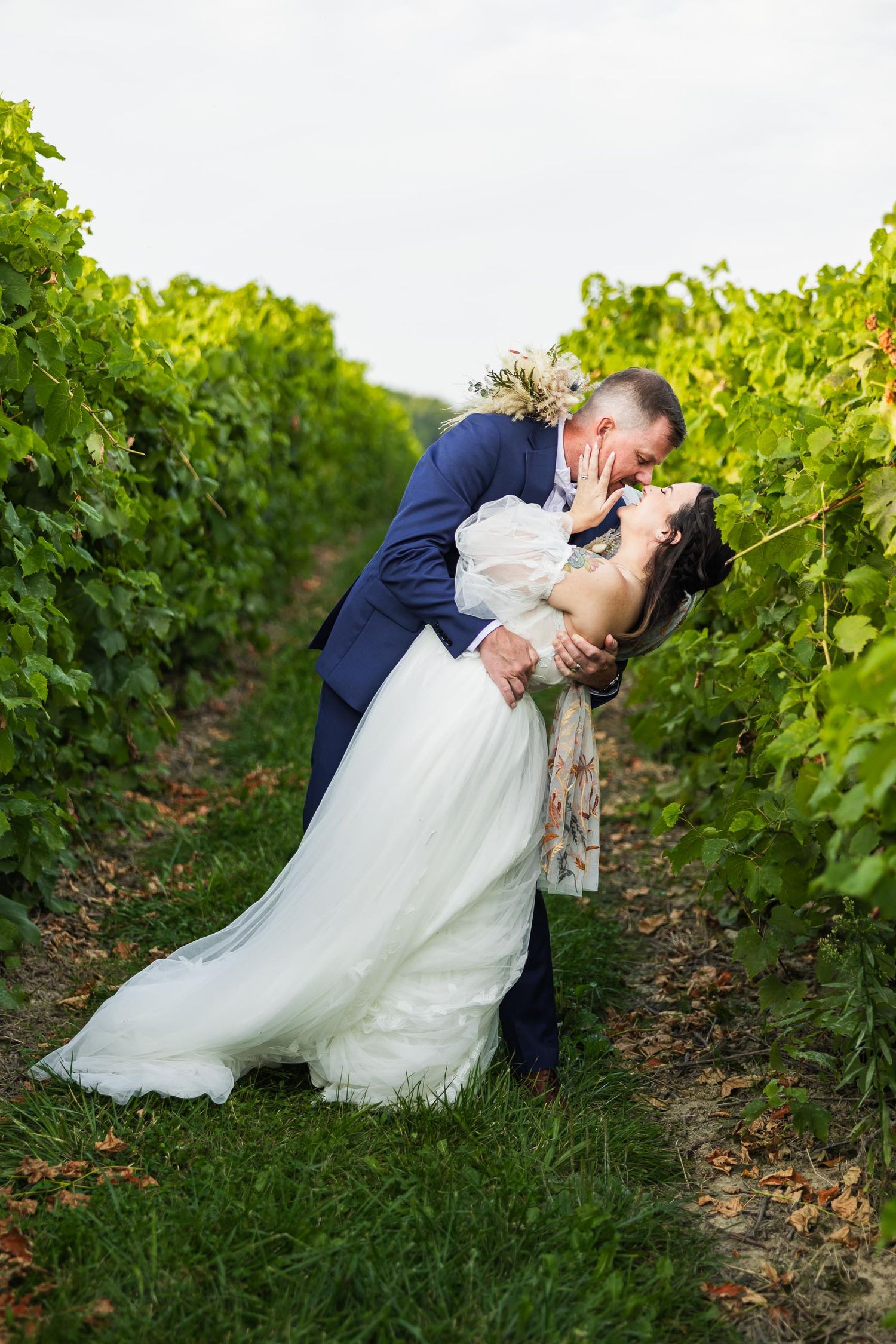 Romantic moment between couple in vineyard during wedding photoshoot.