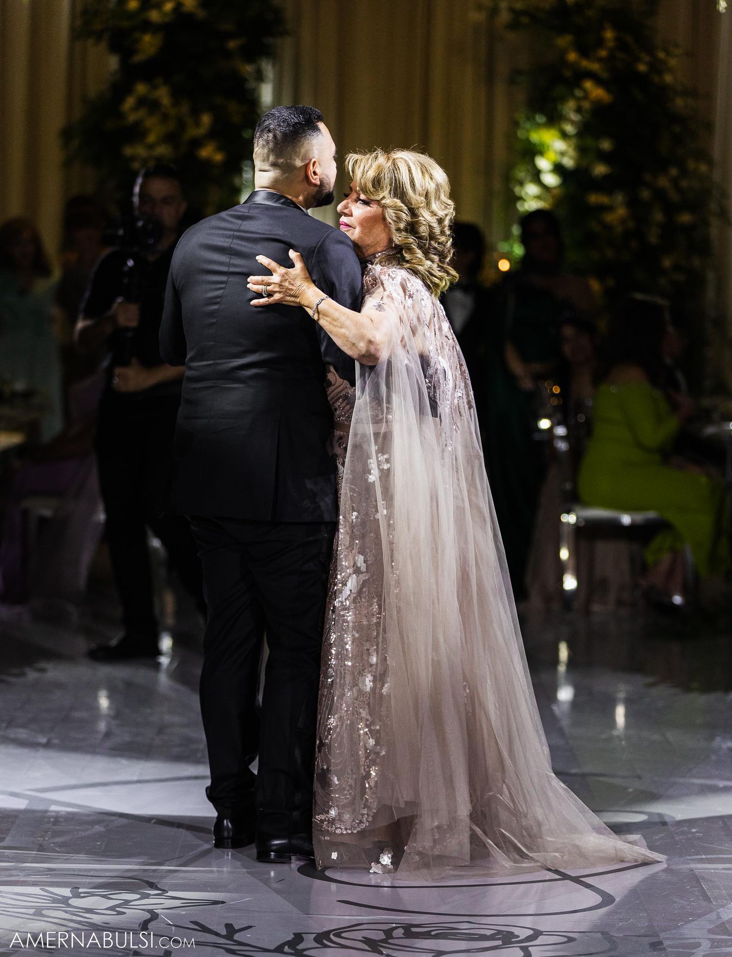 A tender dance moment between a couple at an elegant wedding reception with mood lighting.