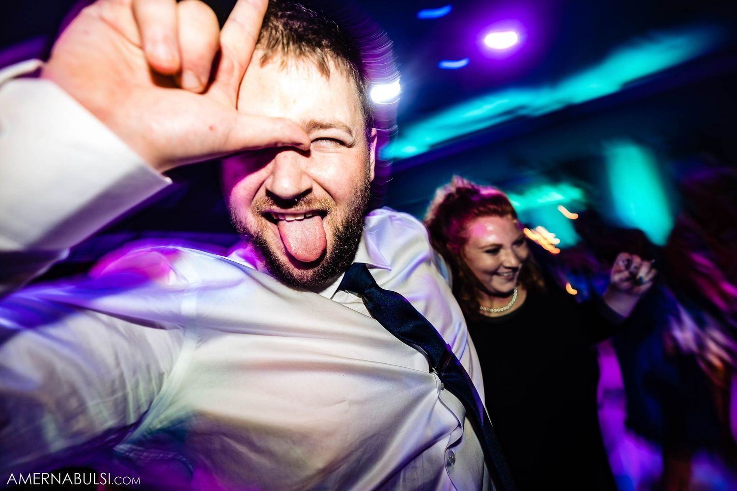 Energetic dance party moment captured under colorful nightclub-style lighting.