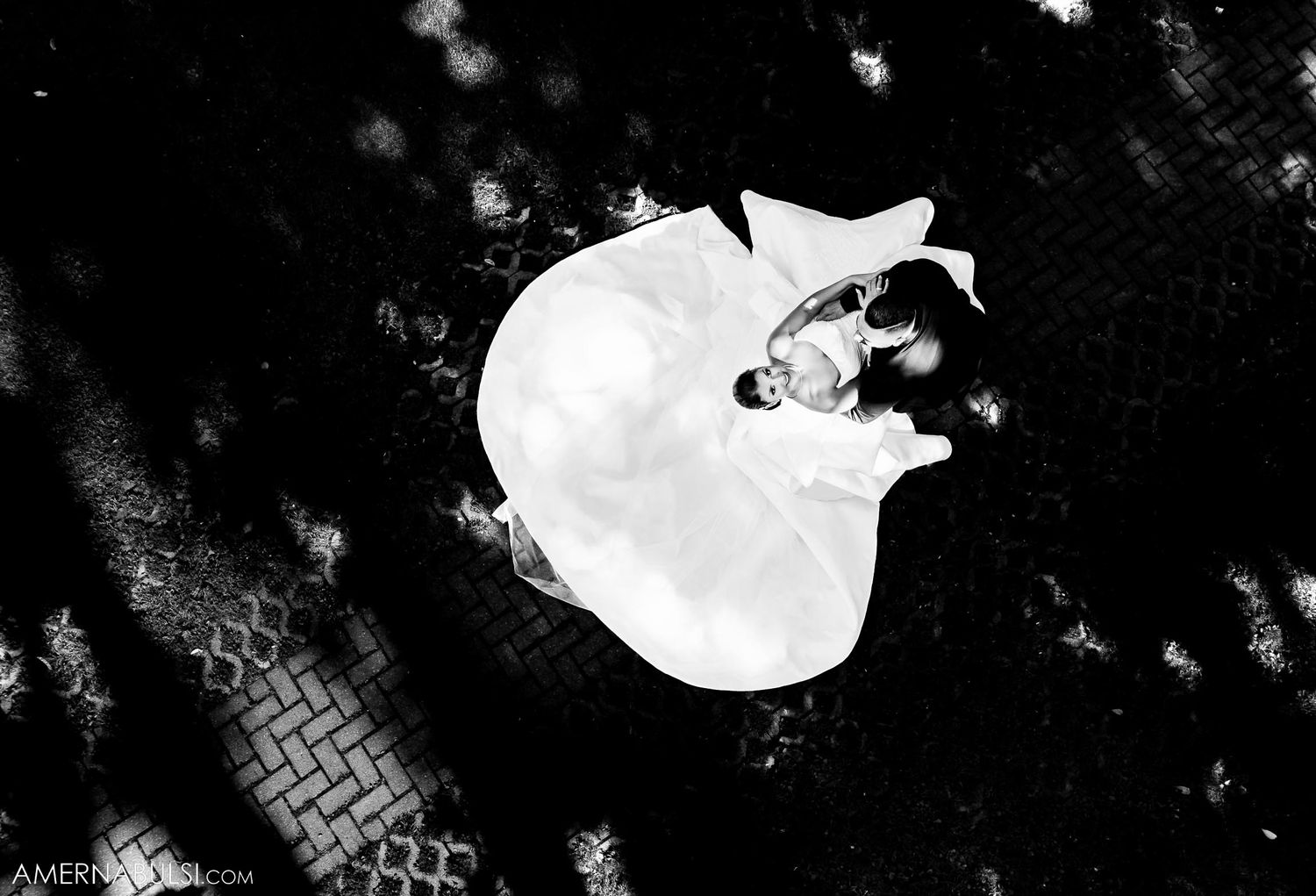 An artistic overhead black and white shot of a couple dancing at their wedding.