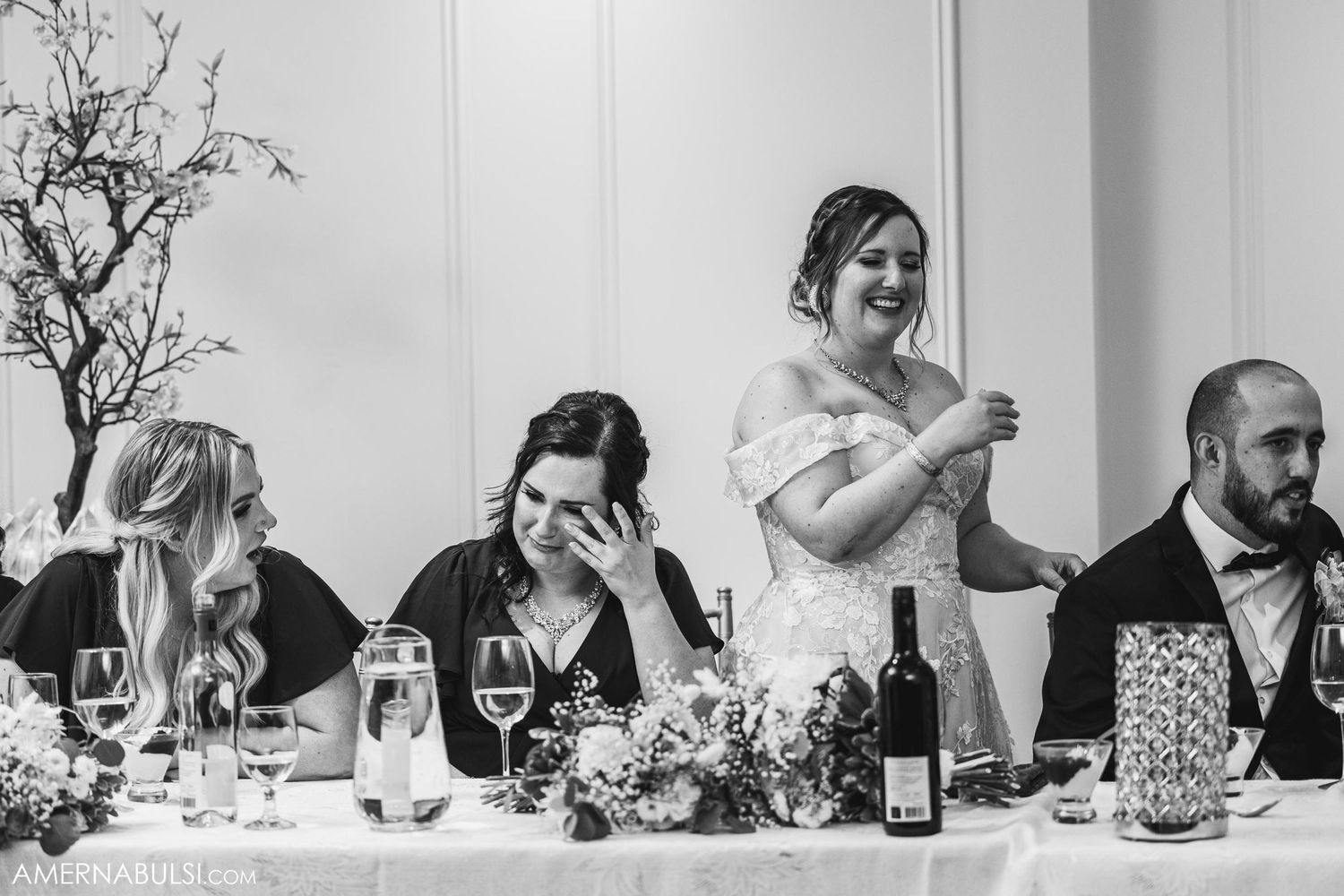 Wedding party sitting at head table during reception toasts and speeches.