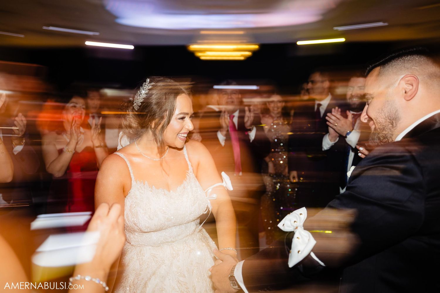 Motion-blurred photo captures dancing and celebration at an elegant wedding reception.