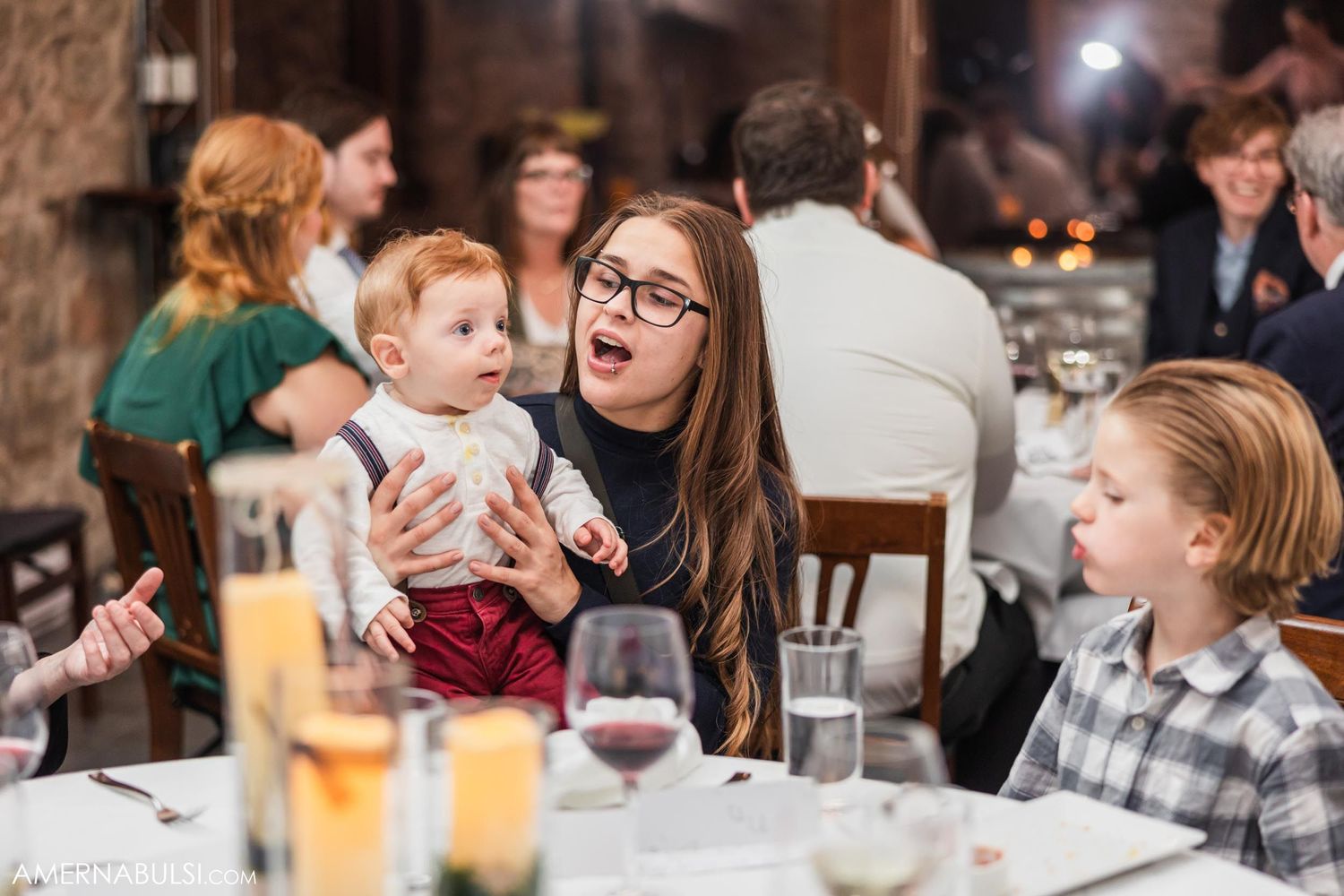 Candid moment of guests enjoying conversation during wedding reception dinner.