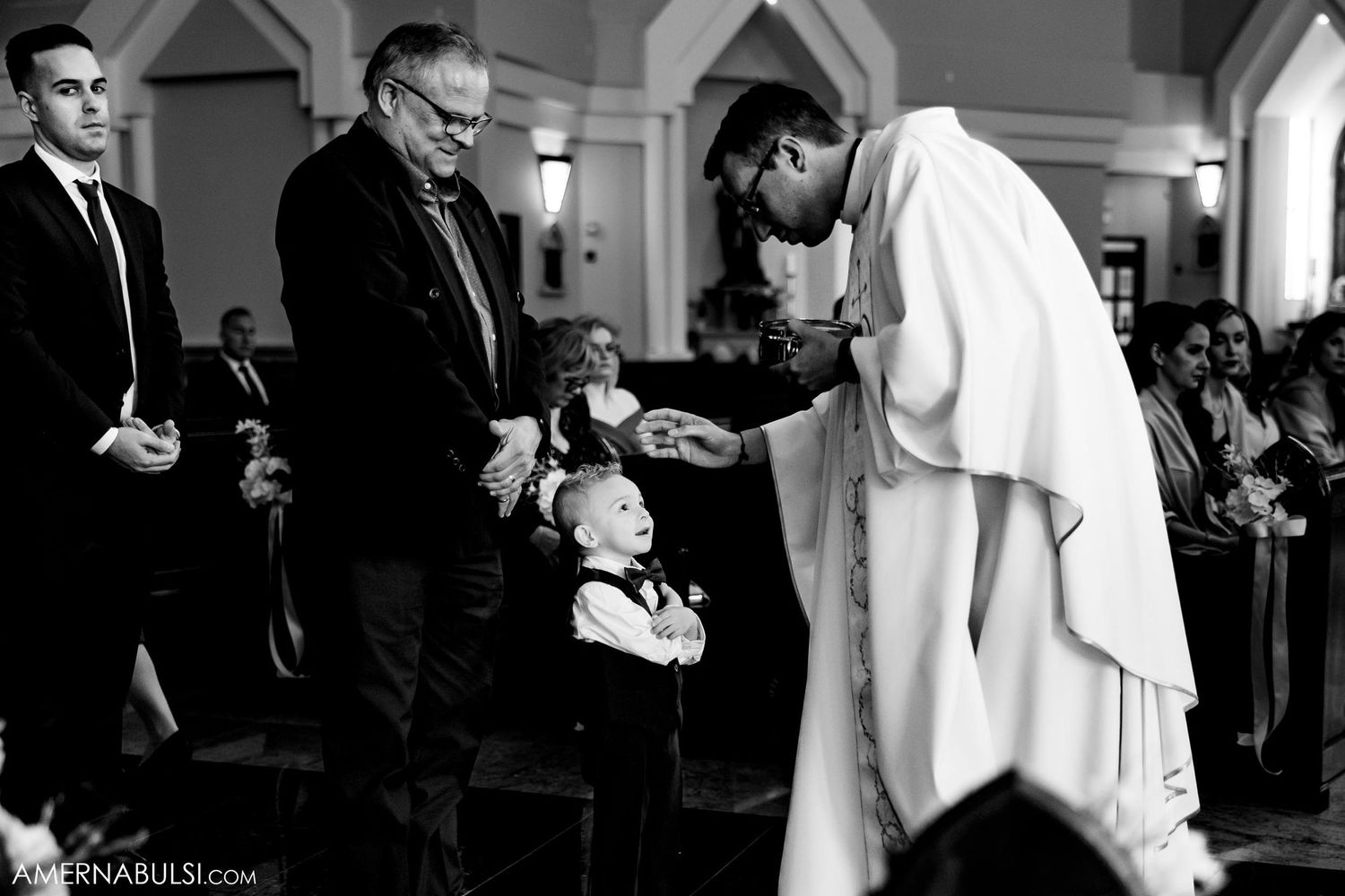 Black and white photo of religious ceremony moment in traditional church setting.