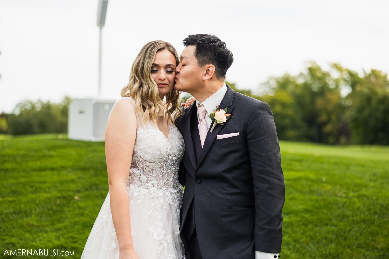 Elegant couple shares intimate moment on golf course during wedding day.