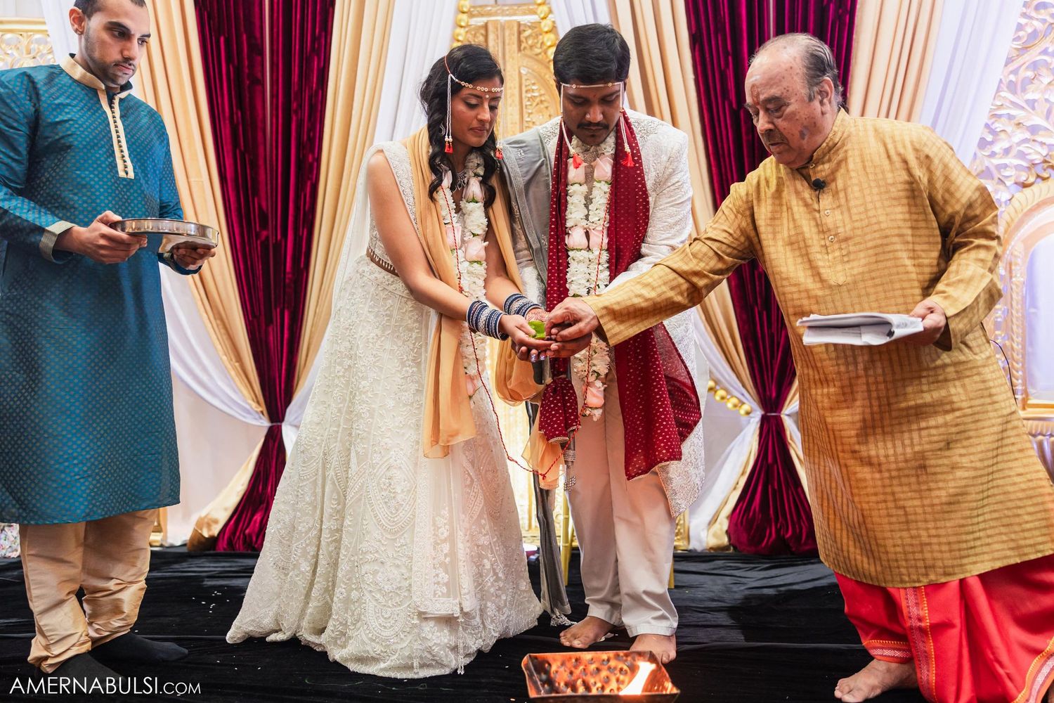 Wedding couple and elders perform sacred rituals around ceremonial fire during Indian marriage ceremony.