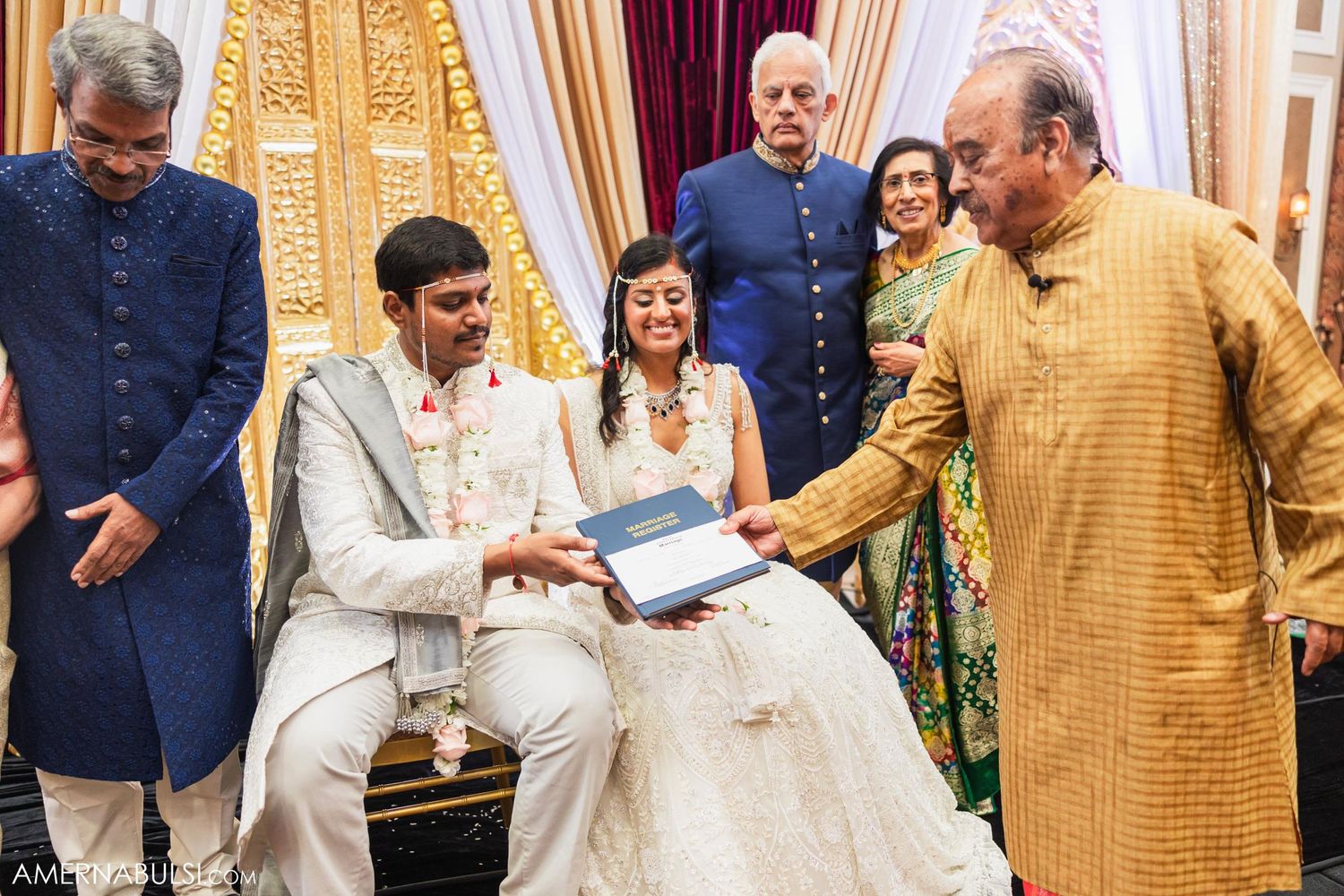 Wedding guests gather around the couple during a traditional Indian gift giving ceremony.
