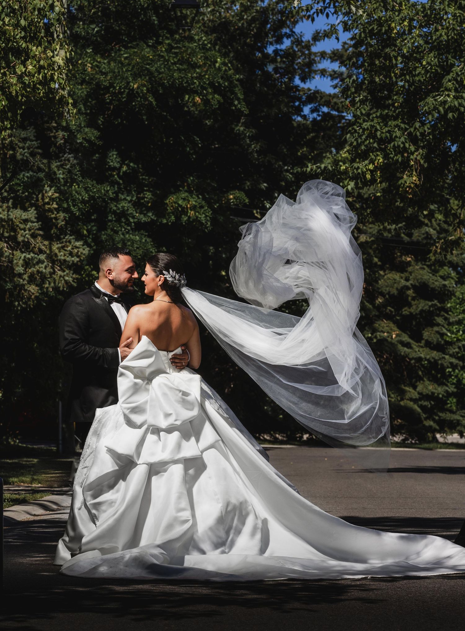 Flowing white wedding dress and veil create dramatic movement in an outdoor photoshoot sequence.