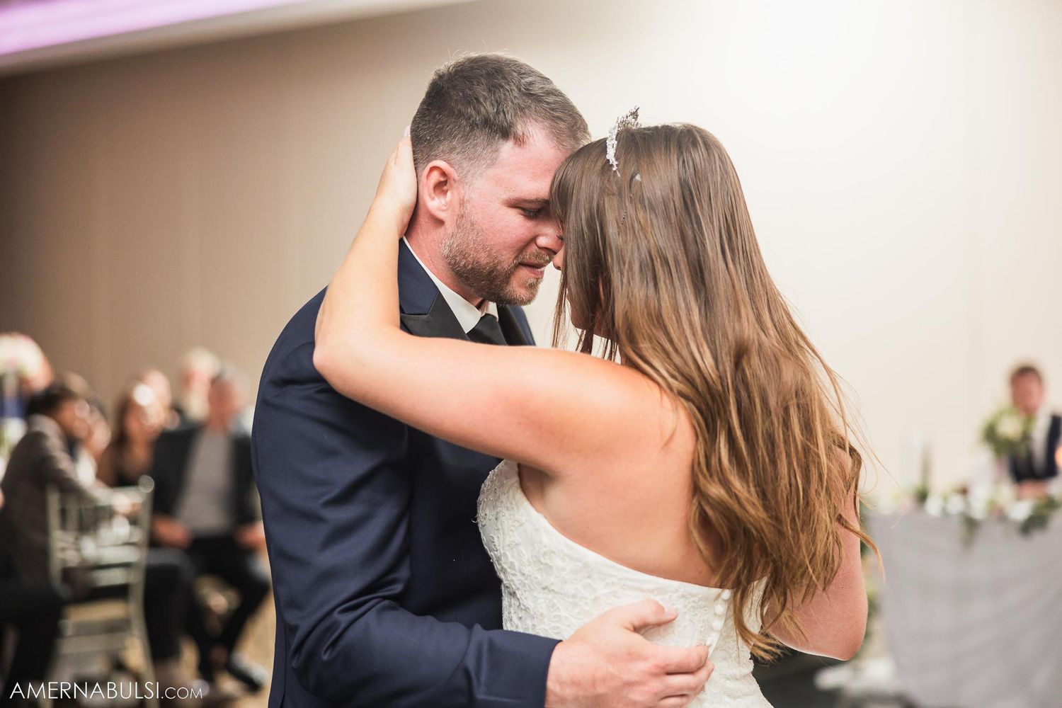Intimate moment between newlyweds during their first dance at wedding reception.
