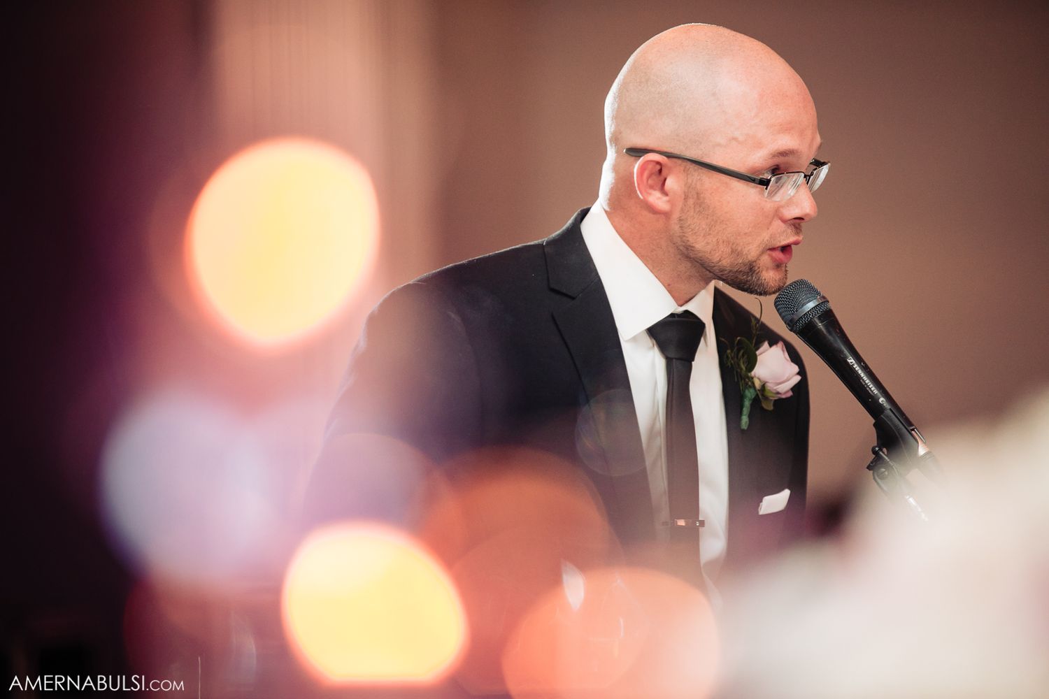 Wedding reception speeches captured in artistic bokeh lighting effects.