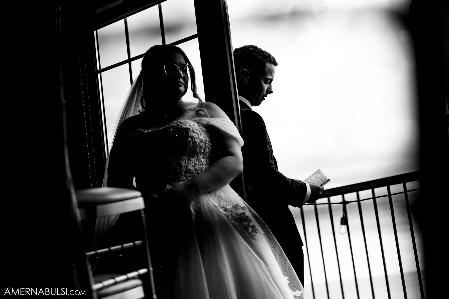 Artistic black and white silhouettes near large window create dramatic bridal preparation scene.