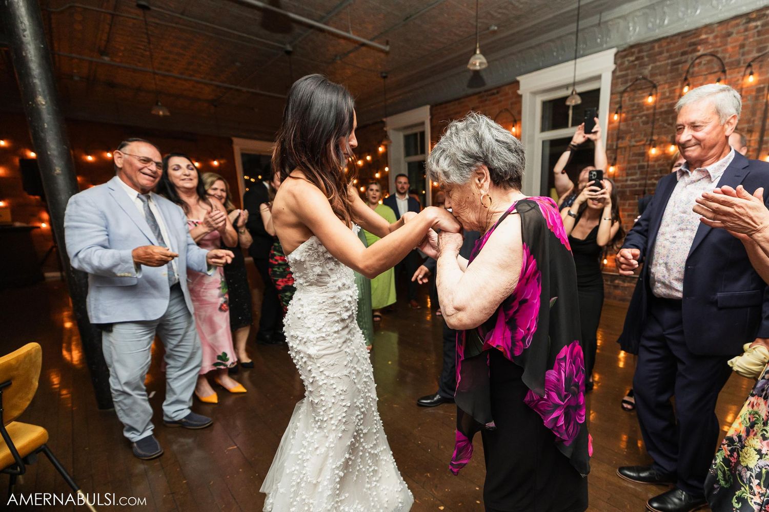 A celebration unfolds on the dance floor as guests watch and applaud.