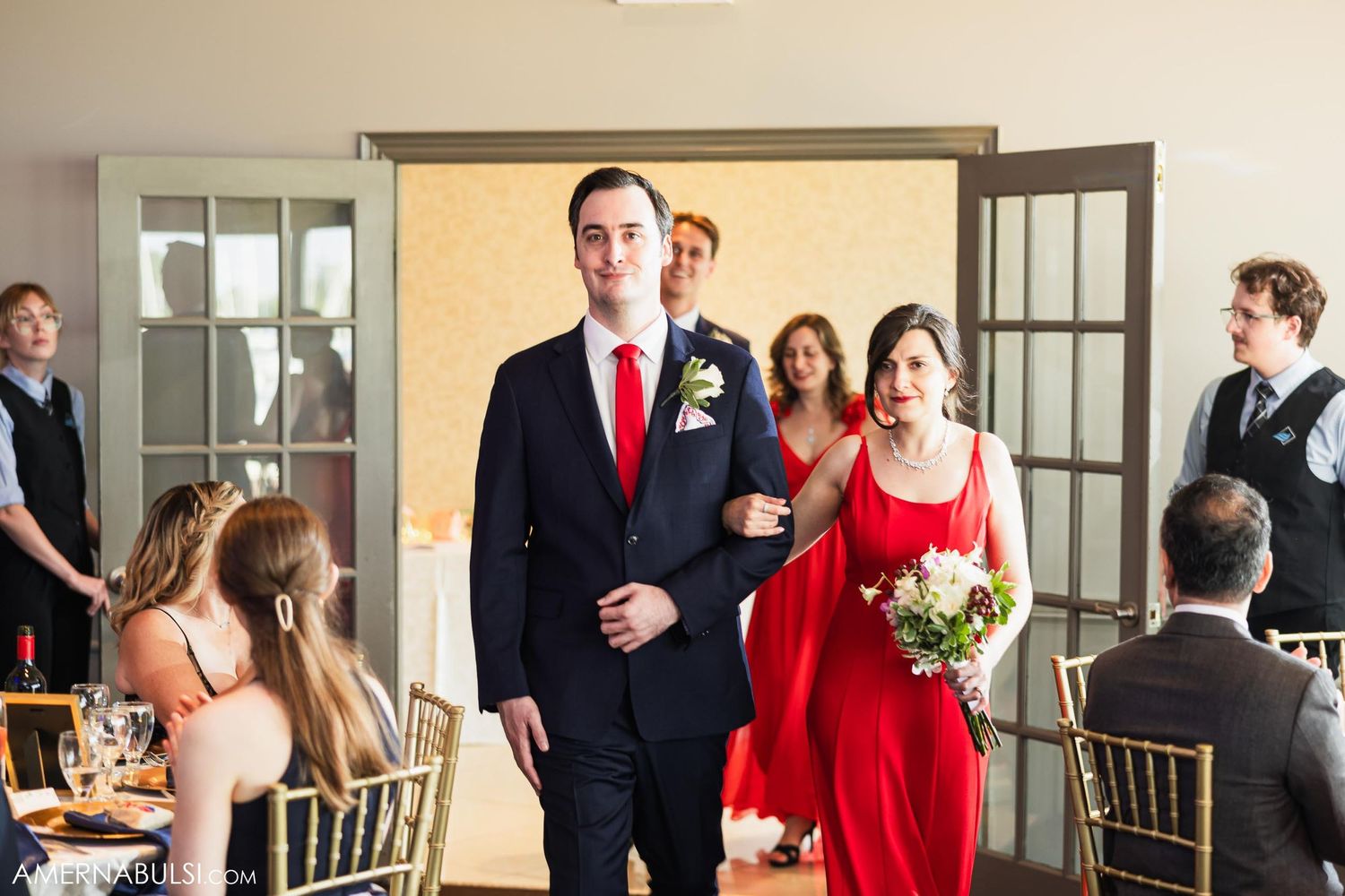 Wedding party members make formal entrance through french doors at reception venue.
