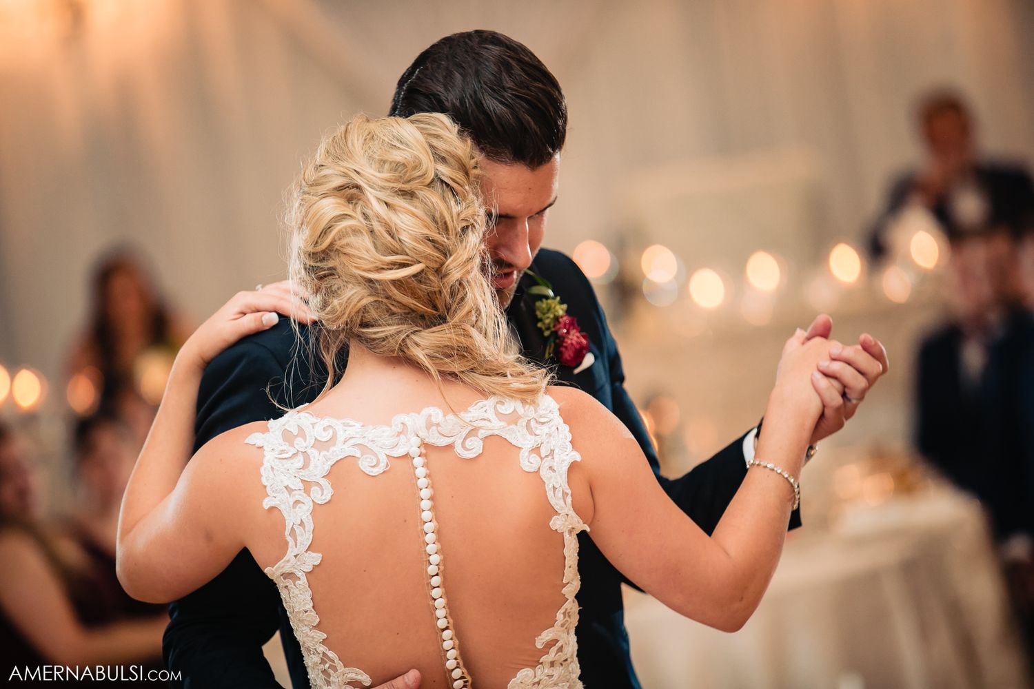 Elegant couple dancing together at a wedding reception with soft lighting and romantic atmosphere.