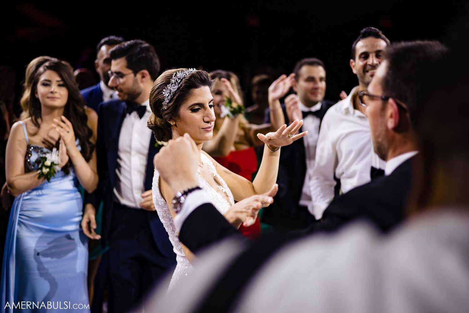 Guests in formal attire dance and celebrate at an elegant wedding reception.
