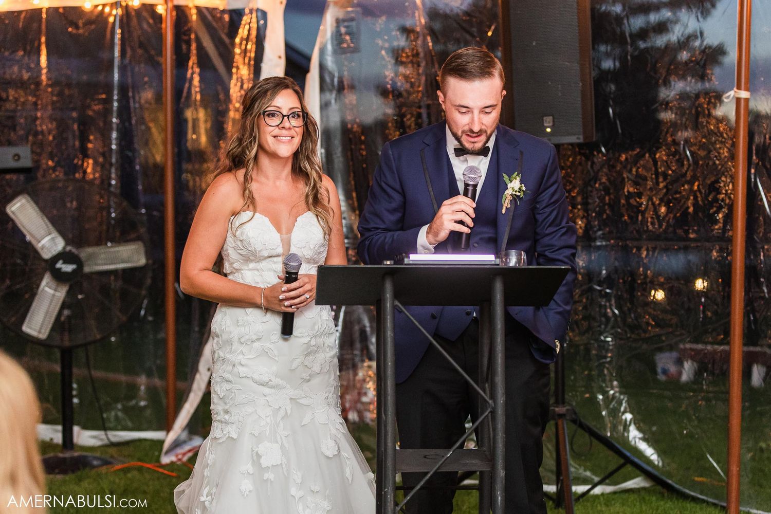 Newlyweds giving emotional toasts during their outdoor evening wedding reception.