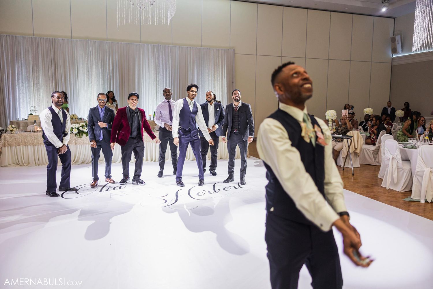 Groomsmen perform a synchronized dance routine at a wedding reception.