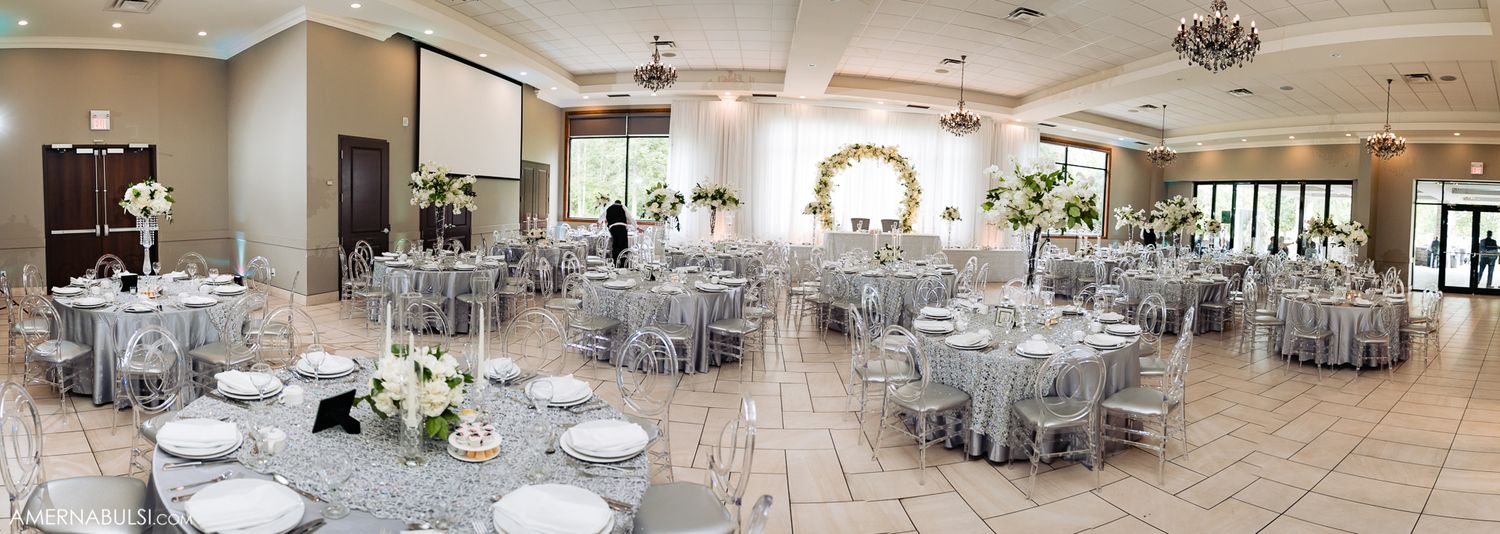 Elegant wedding reception venue with silver and white decor set for dining.
