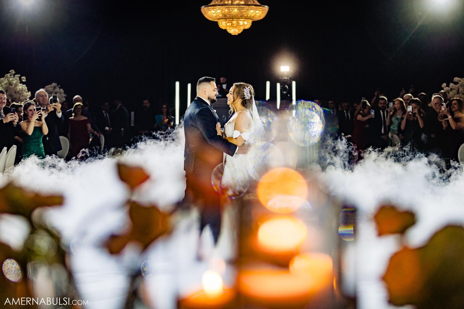 Romantic first dance with low-lying fog and candlelight creating dreamy atmosphere.