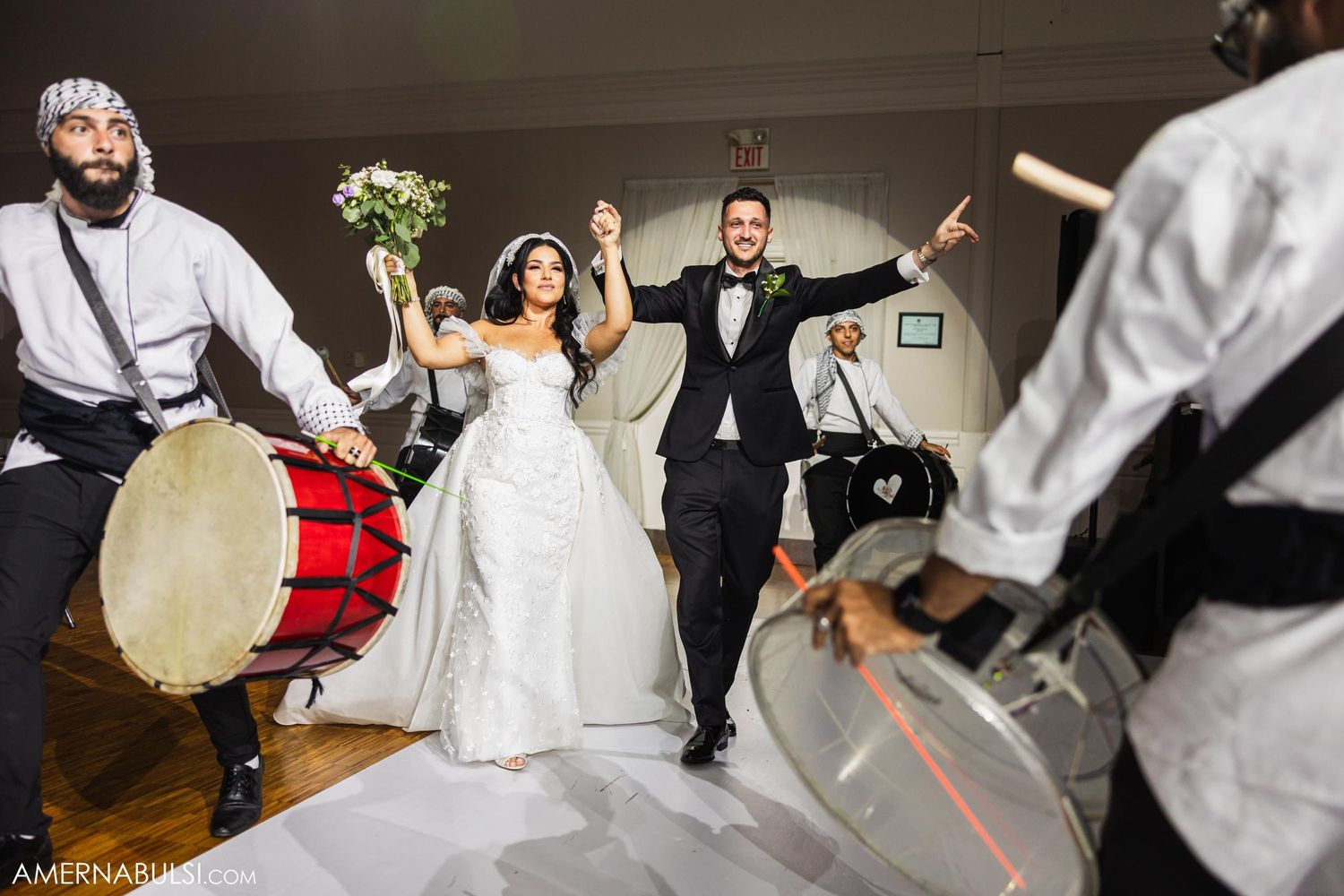 Wedding couple celebrating with traditional drummers during their reception party.