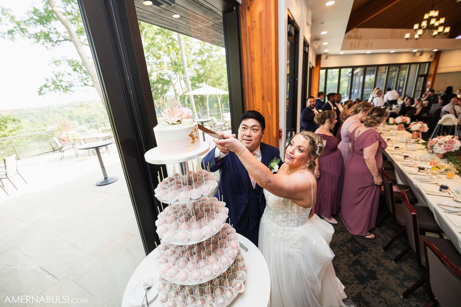 Newlyweds cut their elegant multi-tiered champagne tower at wedding reception.