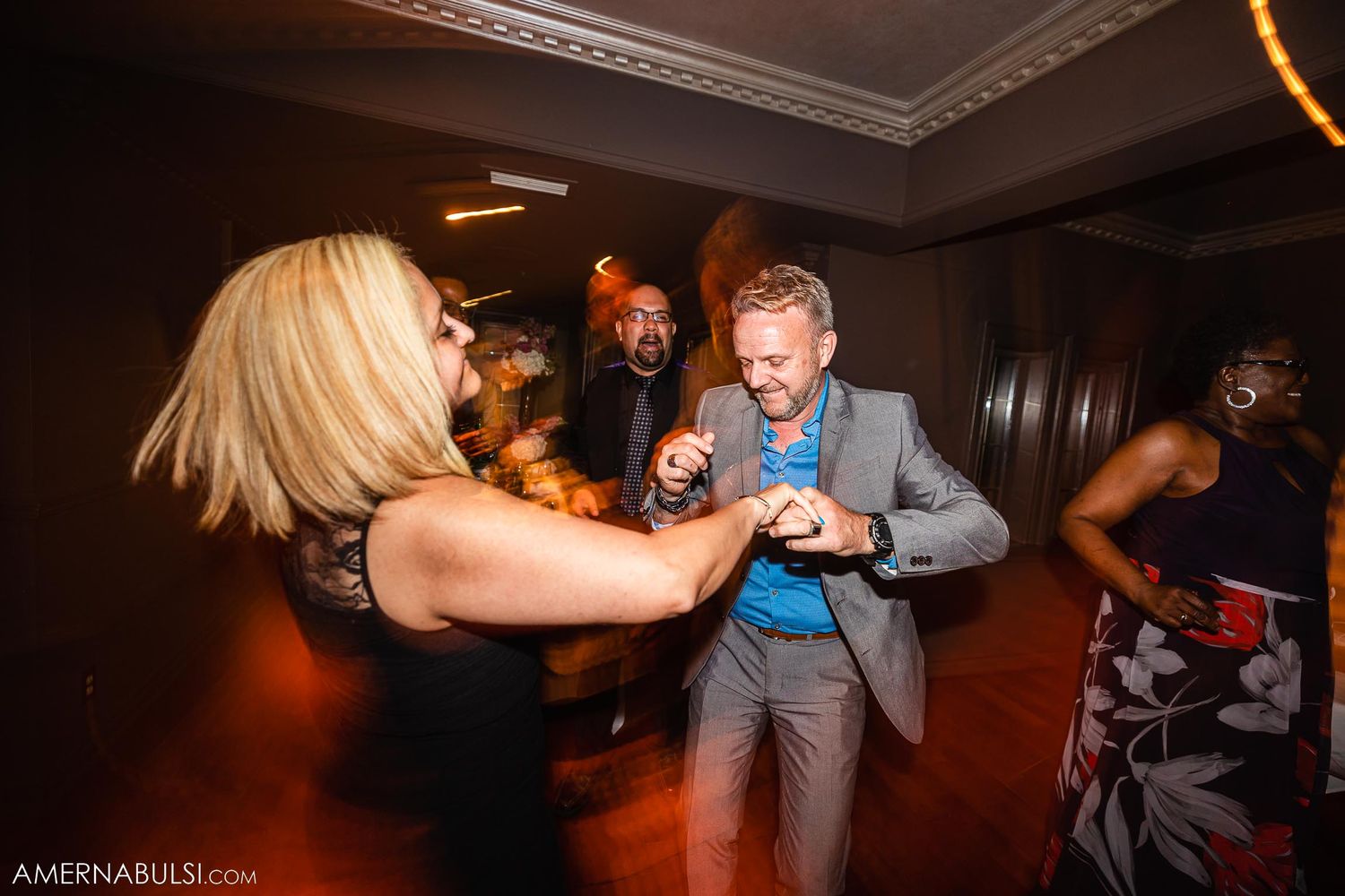 Guests enjoying themselves dancing at lively wedding reception party.