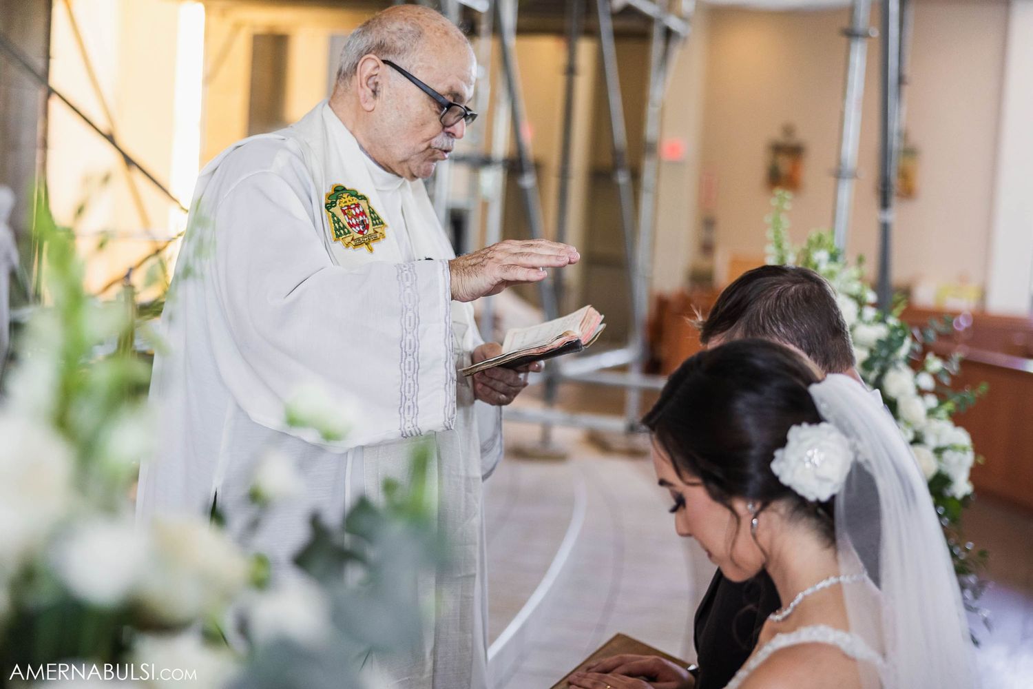 A priest performs a blessing during a traditional Catholic wedding ceremony.