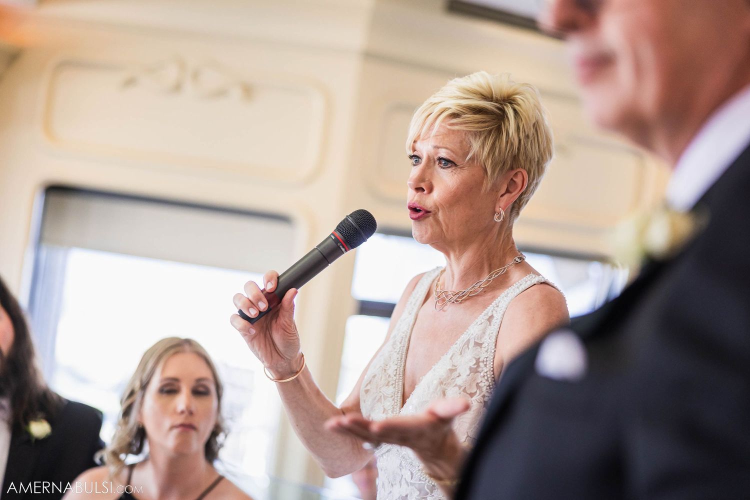 Wedding celebration with speeches and toasts in an elegant ballroom setting.